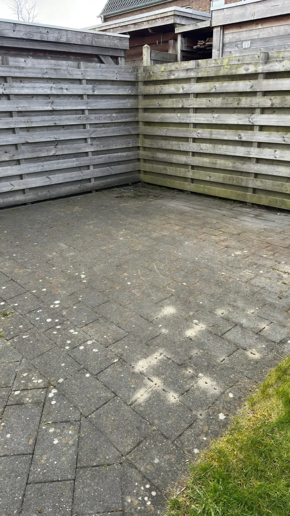 Terras bij een houten schutting, voor de reiniging
