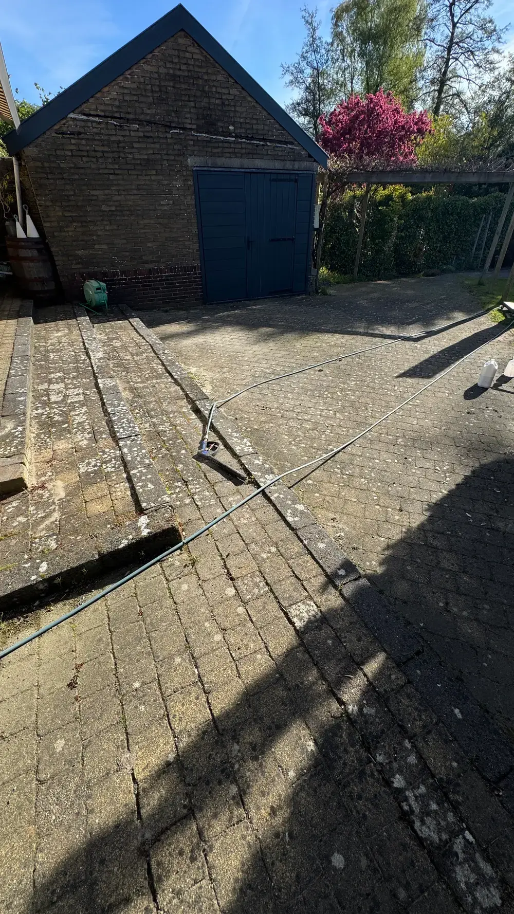 Oprit van klinkers bij een garage, voor de reiniging
