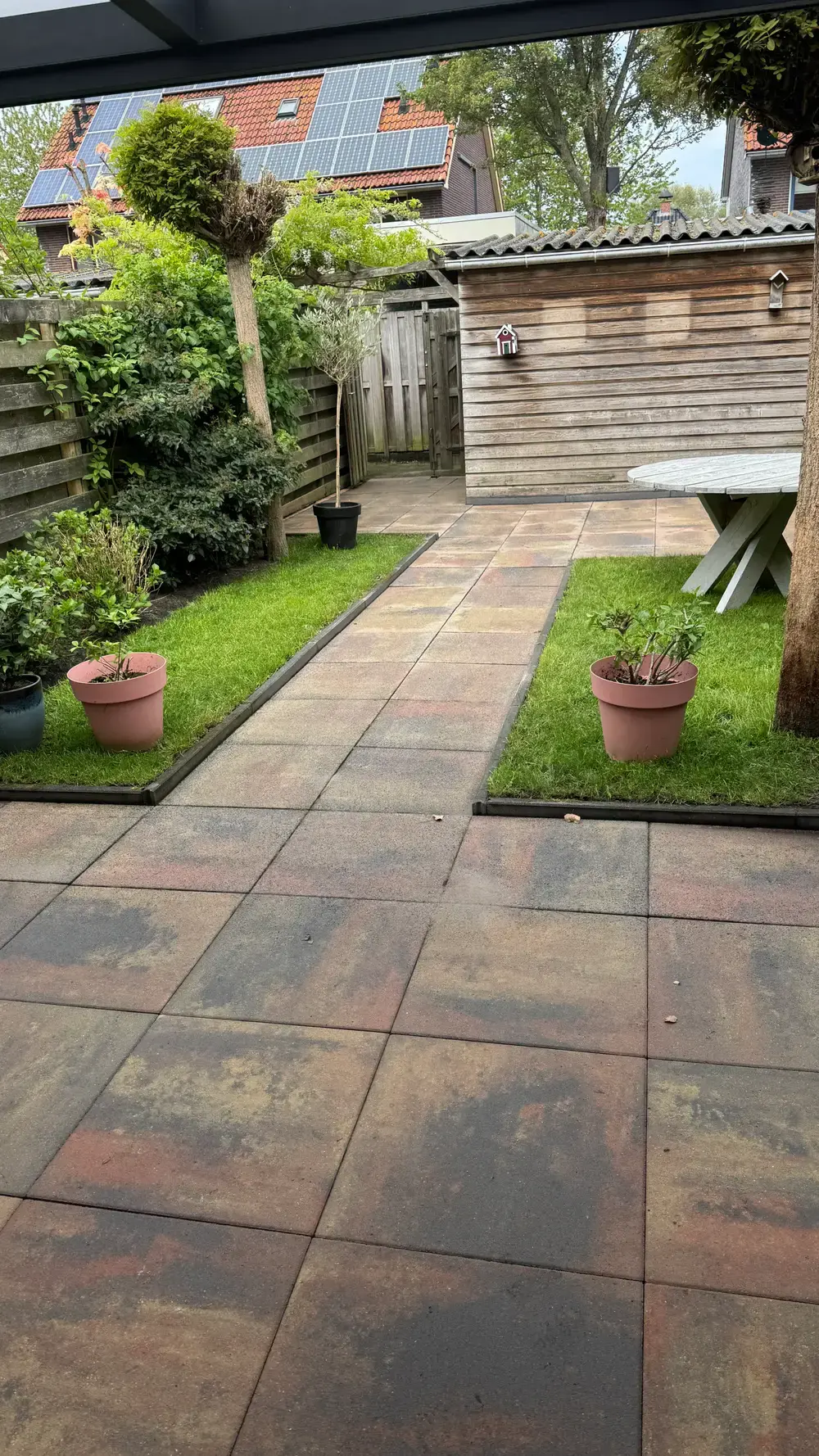 Terras en tuinpad onder een pergola, na de reiniging
