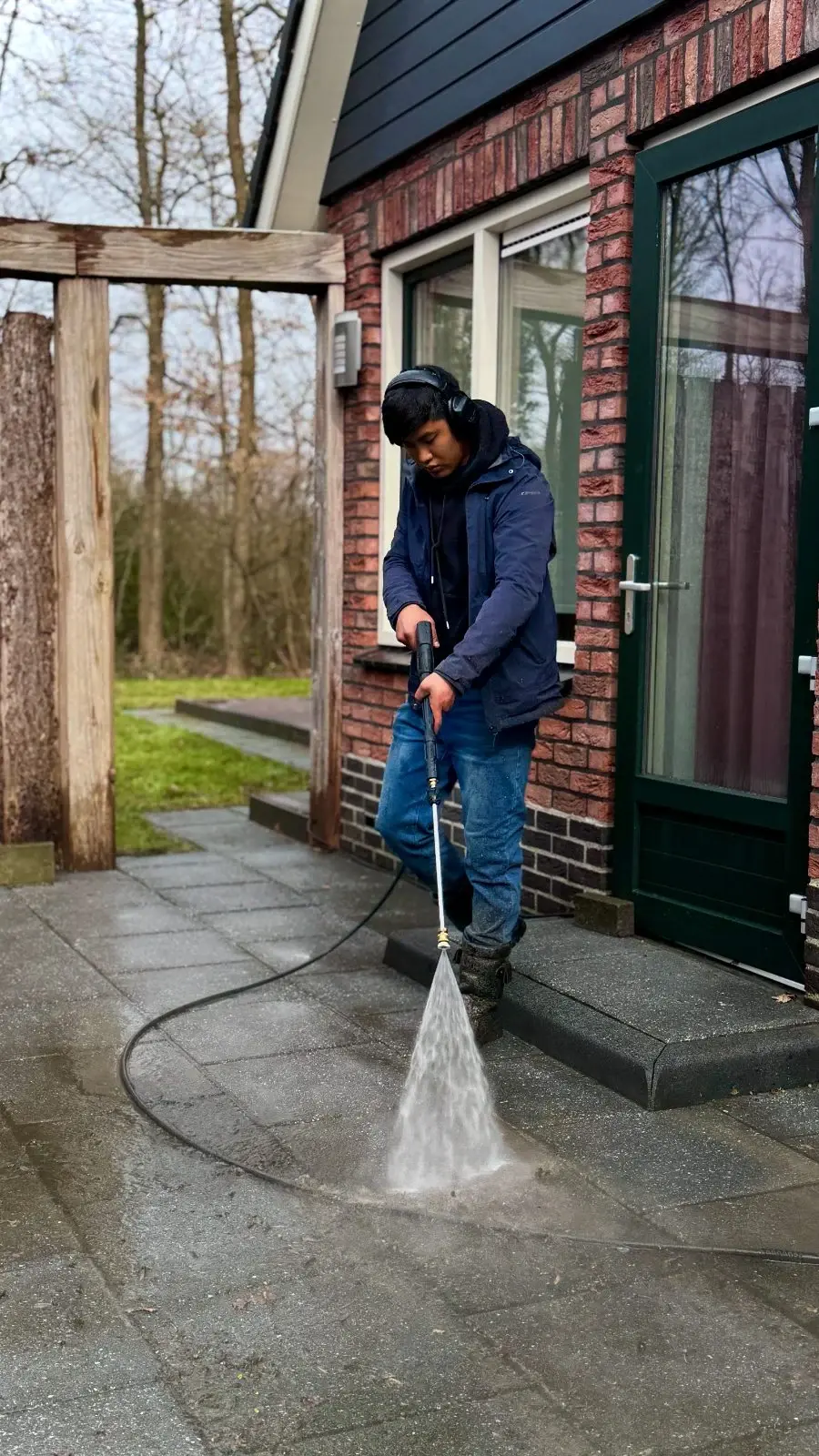 Vakman van De WaterWonders reinigt een terras met de hogedrukreiniger